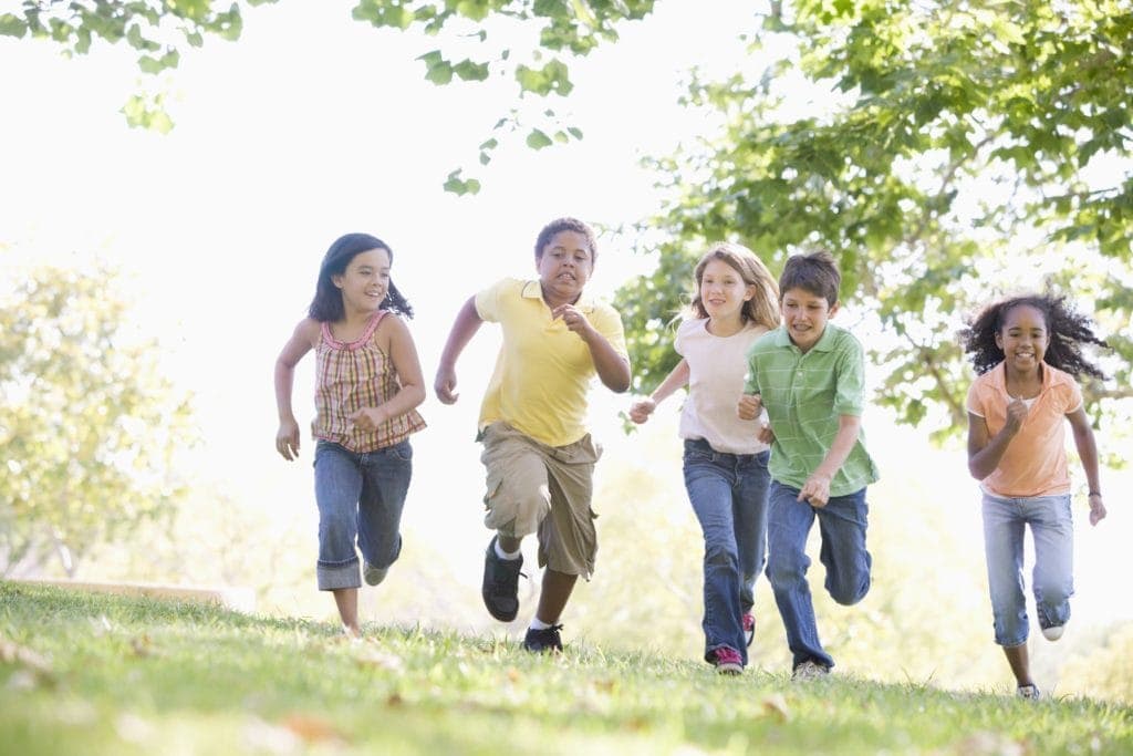 kids running outside in the summer playing a game