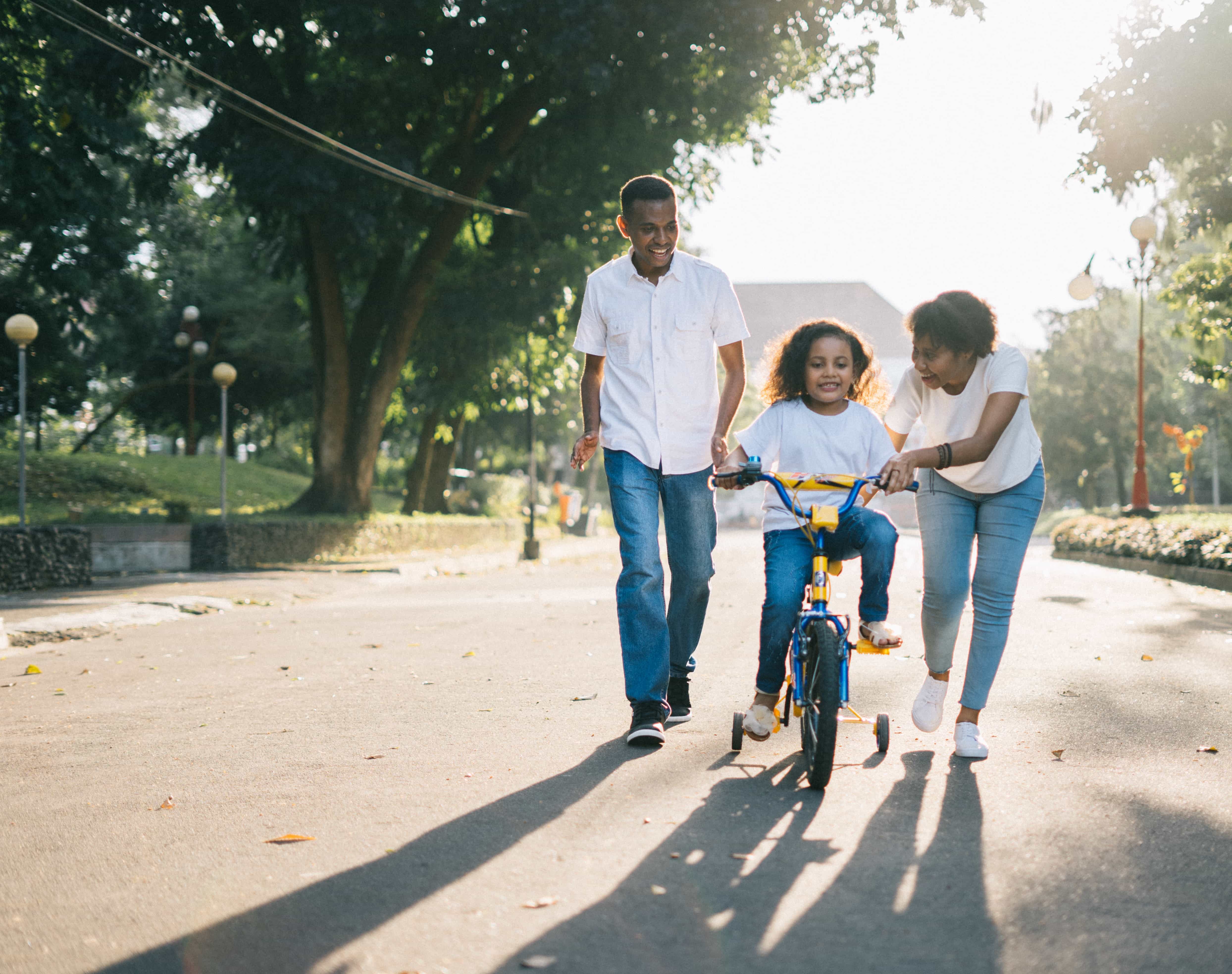 family with kid learning to ride a bike teaching a growth mindset