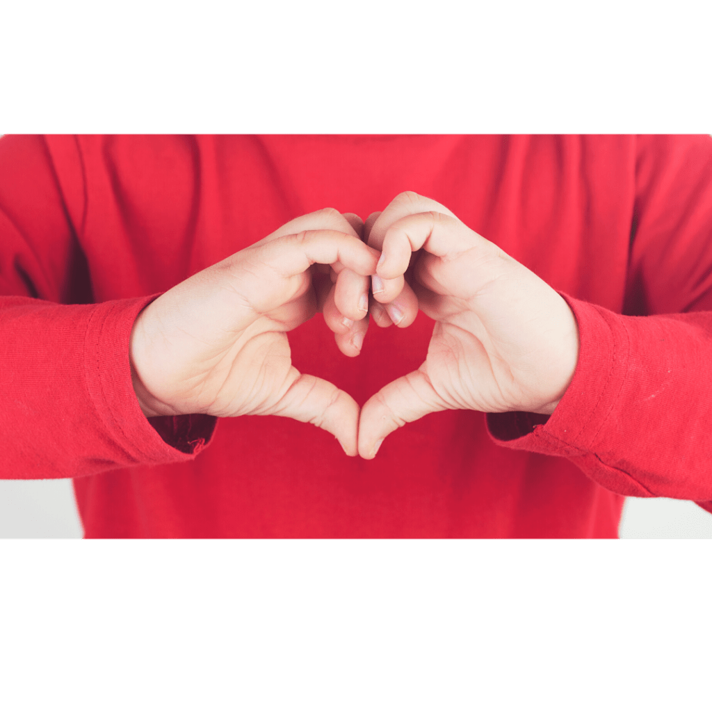 child in red shirt forming heart with hands to illustrate heartfulness breathing technique