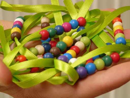 breathing beads, green ribbon with brightly colored wooden beads threaded