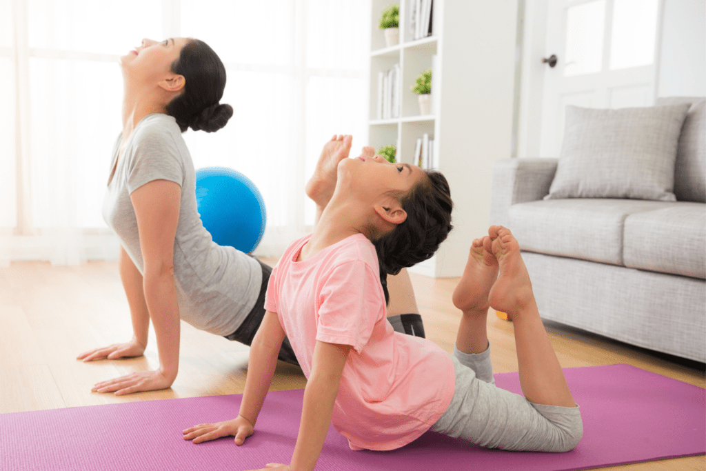 child and parent doing yoga pose swan together