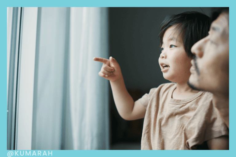 child looking at pointing at something with help of adult